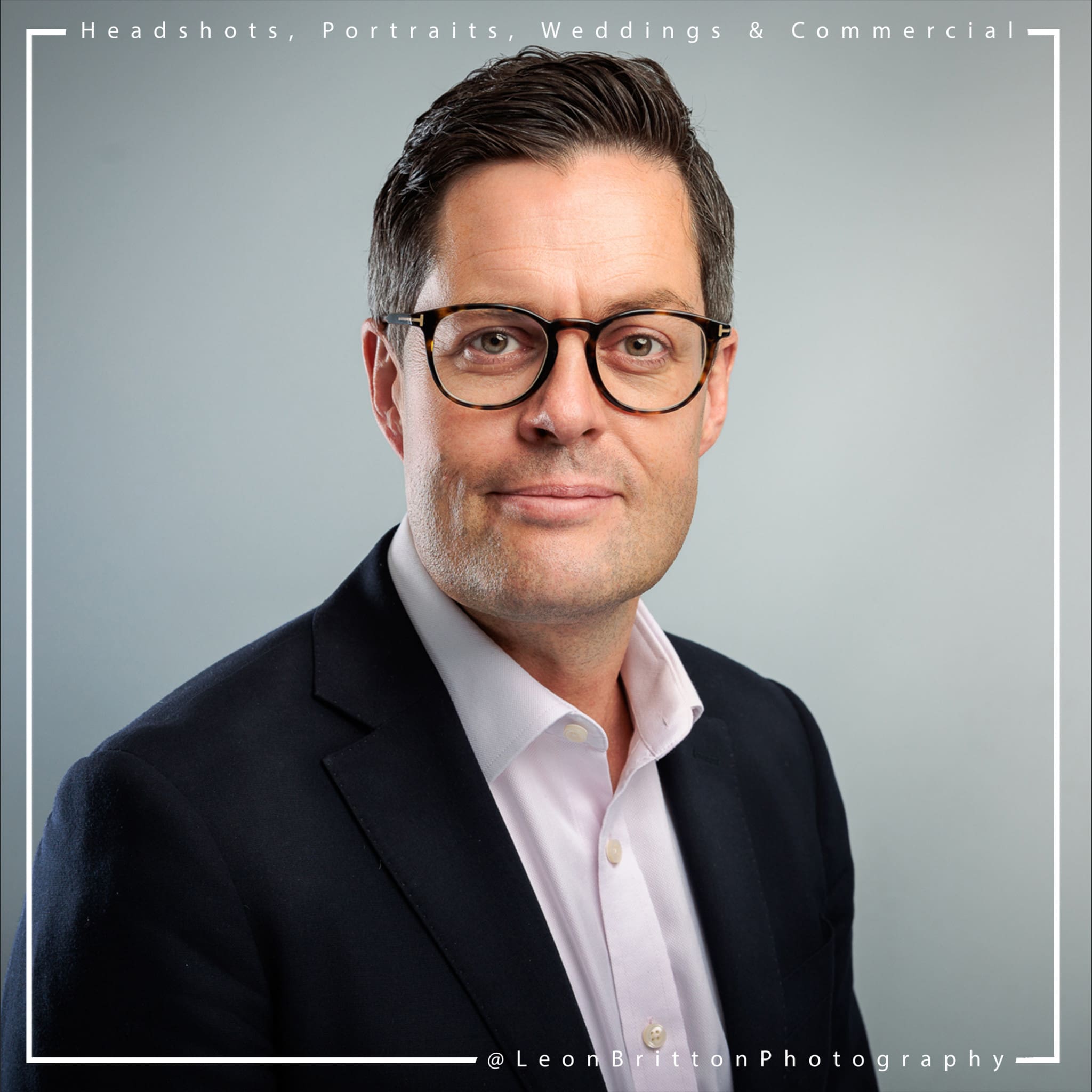 Candid headshot of a man in a corporate setting with natural lighting